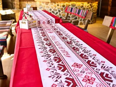 a long table with a red and white table cloth at КЪЩА ЗА ГОСТИ ГРОШЪ in Dobrinishte