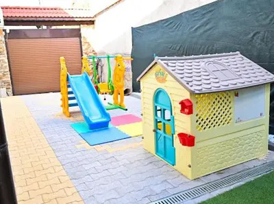 a playground with a toy house and a slide at КЪЩА ЗА ГОСТИ ГРОШЪ in Dobrinishte
