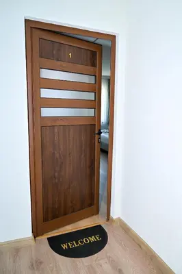 a wooden door with a welcome mat in front of it at КЪЩА ЗА ГОСТИ ГРОШЪ in Dobrinishte