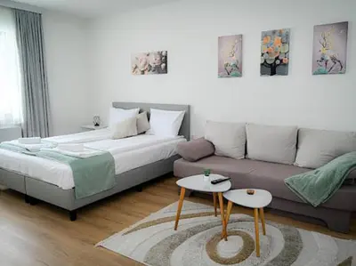 a living room with a bed and a couch at КЪЩА ЗА ГОСТИ ГРОШЪ in Dobrinishte