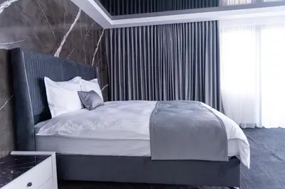 a bedroom with a large bed with white sheets and pillows at A-Dent luxury apartments & Dental Clinic in Gotse Delchev