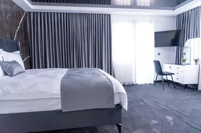 a bedroom with a bed and a desk and a chair at A-Dent luxury apartments & Dental Clinic in Gotse Delchev