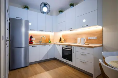 a kitchen with white cabinets and a stainless steel refrigerator at Bright and Cosy 1BD Flat - Perfect for Business Trip by Flat Mаnager in Sofia
