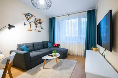 a living room with a couch and a table at Bright and Cosy 1BD Flat - Perfect for Business Trip by Flat Mаnager in Sofia