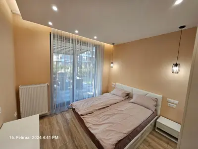 a bedroom with a bed and a large window at Dilyanka in Pernik