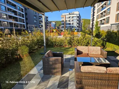 a patio with two chairs and a table and buildings at Dilyanka in Pernik