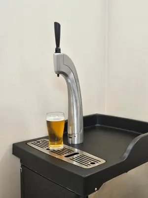 a glass of beer sitting on a counter with a faucet at Villa Geronimo in Bansko