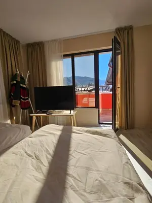 a bedroom with a bed and a desk with a computer at Villa Geronimo in Bansko