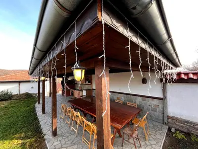 a patio with a wooden table and chairs under awning at Entheos in Vŭrben