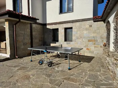 a ping pong table in front of a building at Entheos in Vŭrben