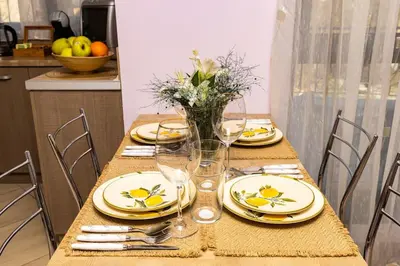 a table with yellow plates and a vase of flowers at Spacious Central Apt by Stefanie / close to MU in Plovdiv