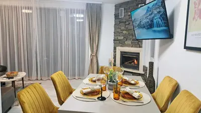 a dining room with a table and chairs and a fireplace at Very cozy and comfort house in top location in Bansko
