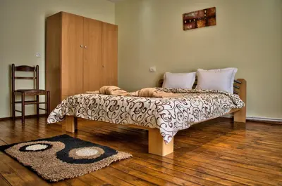 a bed in a room with a wooden floor at Dariya Guest House in Sapareva Banya