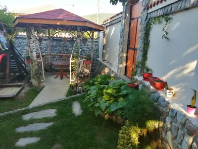 a garden with a stone wall and a gazebo at Dariya Guest House in Sapareva Banya