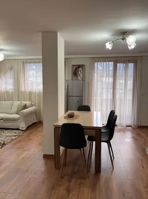 a living room with a dining room table and chairs at Двуспален апартамент в к-с Пирин Палас in Bansko