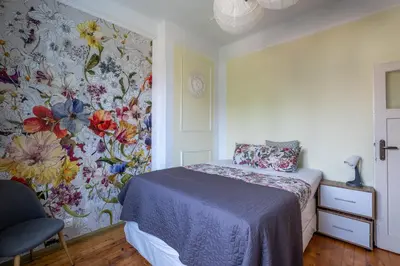 a bedroom with a bed with a floral wallpaper at Classy apartment in Sofia