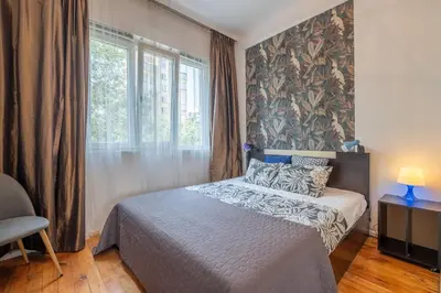 a bedroom with a bed and a large window at Classy apartment in Sofia