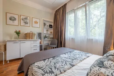 a bedroom with a bed with a dresser and a window at Classy apartment in Sofia