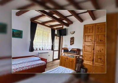 a bedroom with a bed and a desk in a room at ВИЛА ПЕРИКА-Vila PERIKA in Borino