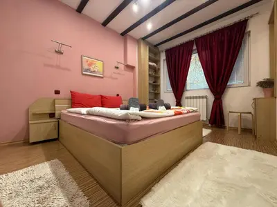 a bedroom with a large bed in a pink room at The Maisonette in Sofia's Heart in Sofia