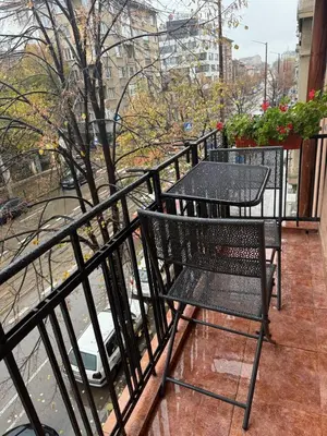 a black table and chair on a balcony at The Maisonette in Sofia's Heart in Sofia
