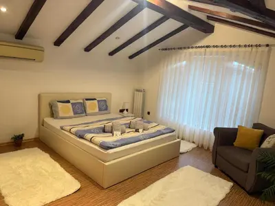 a bedroom with a large bed and a window at The Maisonette in Sofia's Heart in Sofia
