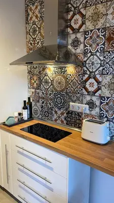 a kitchen with a stove and a tile wall at Bohemian Central Apartment Sofia in Sofia