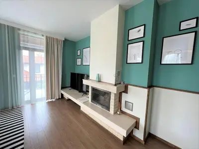a living room with a fireplace and green walls at Private Villa in Ruskovets in Dobrinishte