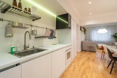 a kitchen with white cabinets and a sink and a table at The Griffin in Sofia