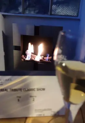 a glass of wine sitting next to a fireplace at INSTA Haus in Plovdiv