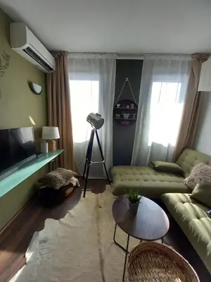 a living room with a couch and a table at Top Top location Green apartment in Bansko