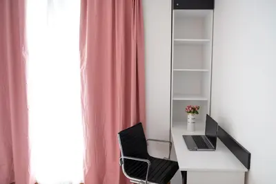 a desk with a laptop computer on it next to a window at Sunny 1BDR Apartment near Center in Sofia