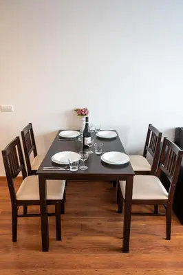 a black table with chairs and plates and a vase at Sunny 1BDR Apartment near Center in Sofia