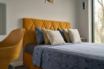 a bed with a blue blanket and pillows on it at Scandinavian Stay - Awarded Bldg - Downtown in Sofia