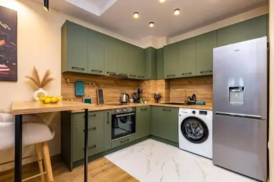 a kitchen with green cabinets and a washer and dryer at Green Hills Plovdiv close to Medical University in Plovdiv