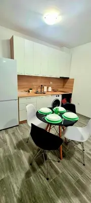 a kitchen with two tables and chairs and a refrigerator at Flower home 10 in Sofia