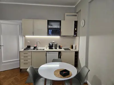 a small kitchen with a white table and chairs at Studio 72 in Sofia