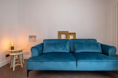 a blue couch in a living room with a mirror at SOHO 13 - Black & White in Sofia