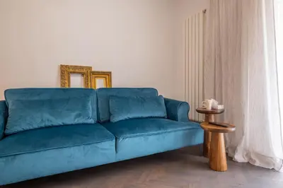 a blue couch in a living room with a mirror at SOHO 13 - Black & White in Sofia