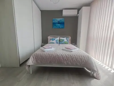a bedroom with a bed with a pink bedspread at Central, brand new apart with parking in Blagoevgrad