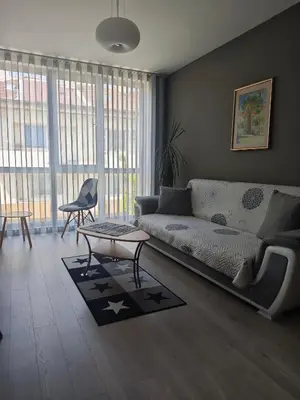 a living room with a couch and a table at Central, brand new apart with parking in Blagoevgrad