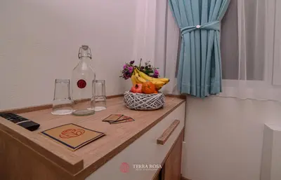 a table with a bottle and a bowl of fruit at Хотел Терра Роза in Karlovo