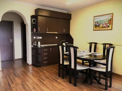 a kitchen and dining room with a table and chairs at Апартамент Веирас in Velingrad