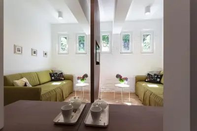 a living room with two green couches and windows at Gorgeous apartment in the perfect area in Sofia