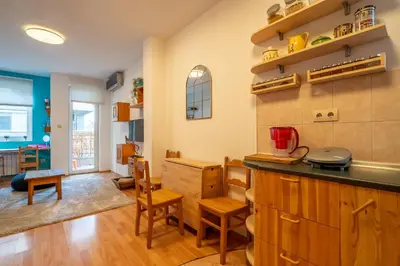 a kitchen with a counter and chairs and a table at 1 Bedroom Natural Condo in Sofia