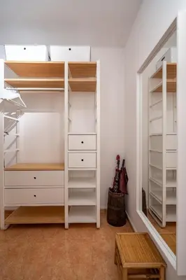 a walk in closet with white cabinets and shelves at 1 Bedroom Natural Condo in Sofia