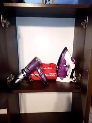 a shelf with a bottle of lipstick and a razor at 