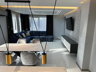 a living room with a couch and a table and chairs at Regatta Park 2BR Exclusive Suite Parking Included in Plovdiv