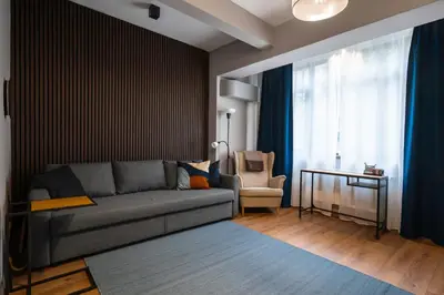 a living room with a couch and a chair at Lux Flat next to Park with working space by Flat Mаnager in Sofia