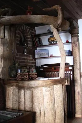 a log cabin with a fireplace and a shelf with a train on it at Шапкова Къща in Delchevo